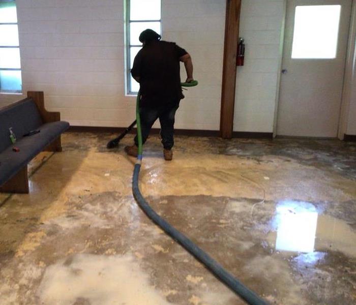 man extracting water from all over the floor 